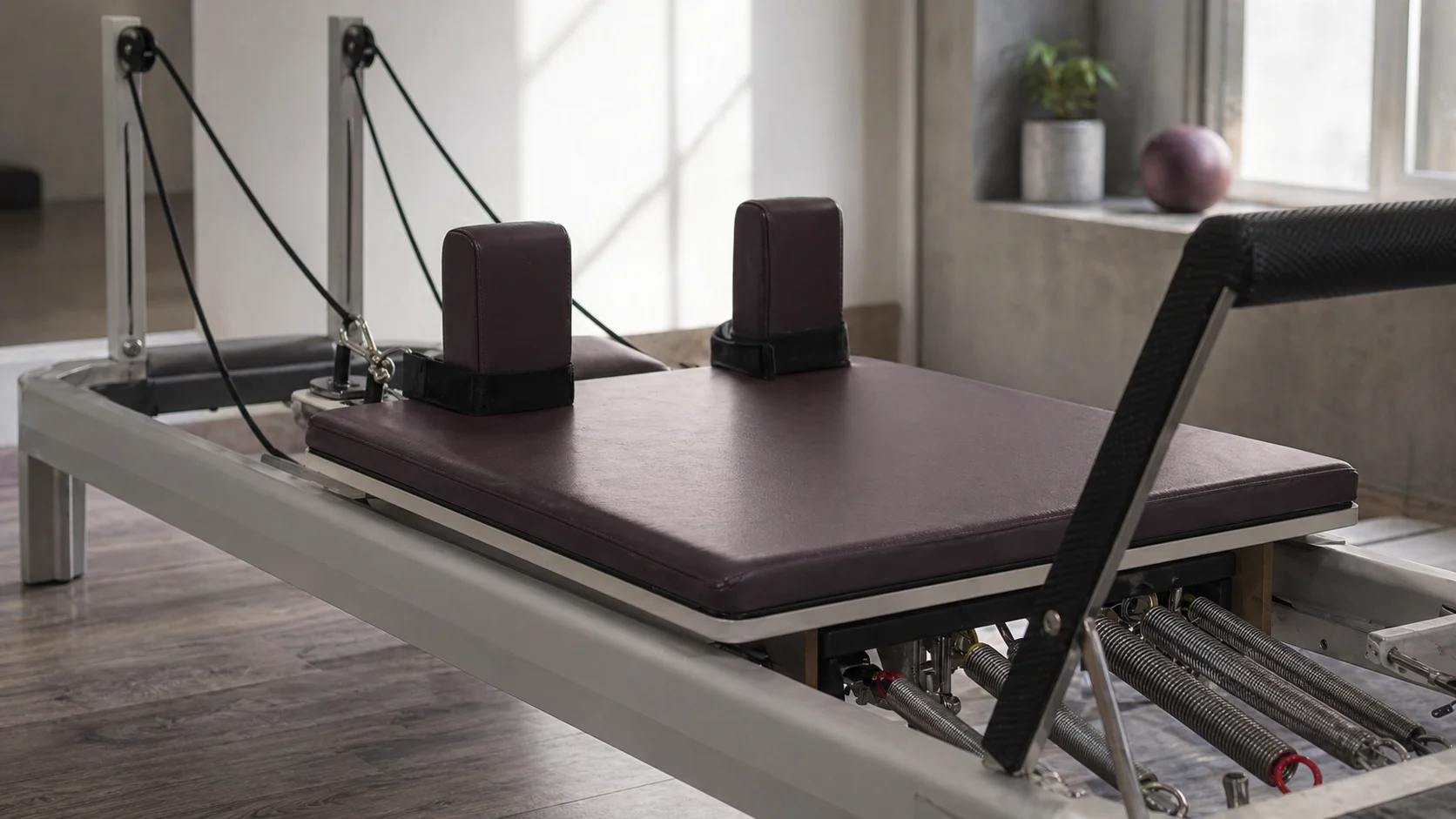 Aparat reformer într-un studio curat — diferența dintre pilates mat și lucrul cu rezistență ghidată
